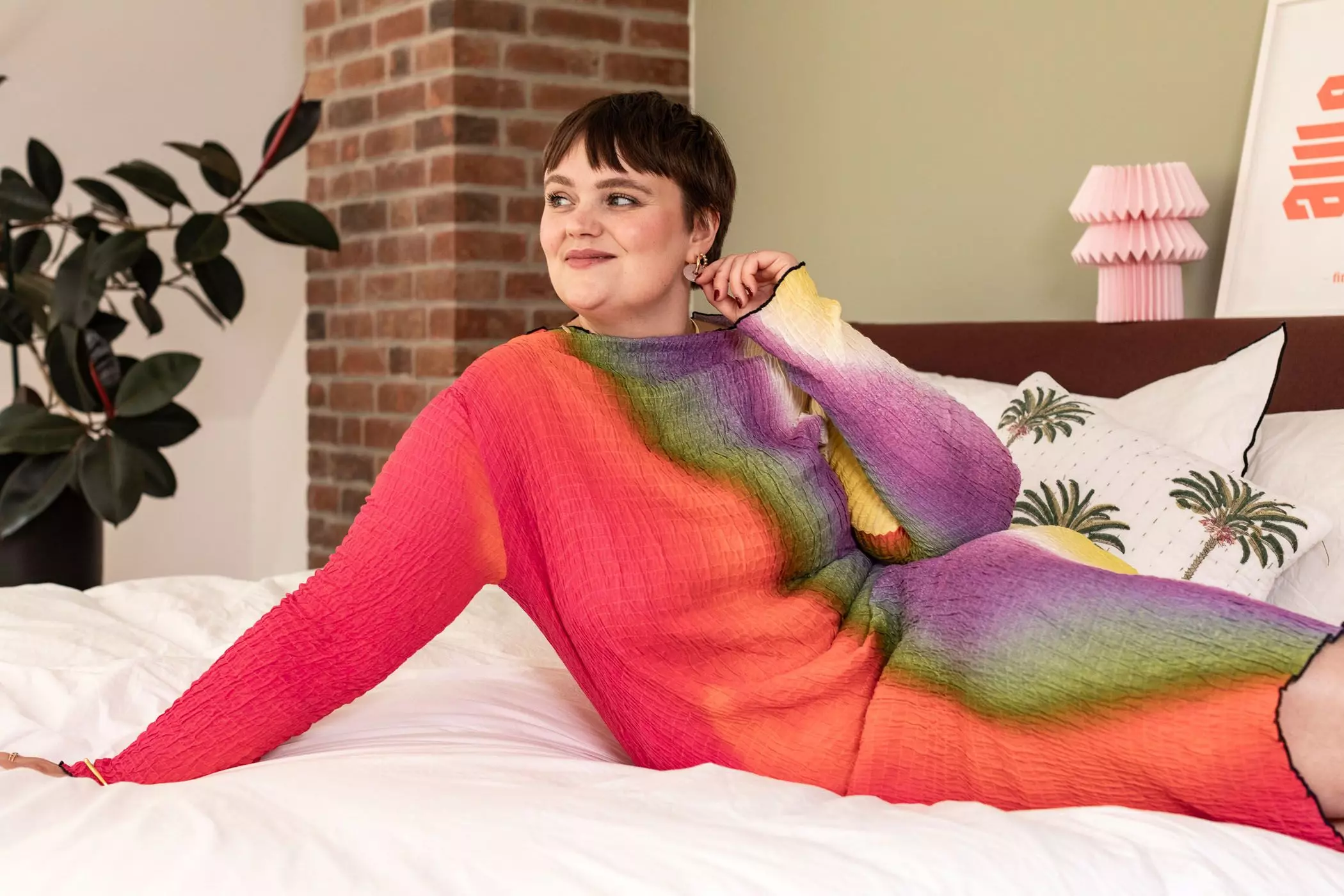 Charlotte Kuhrt liegt in einem bunten Kleid auf ihrem Bett - femtastics