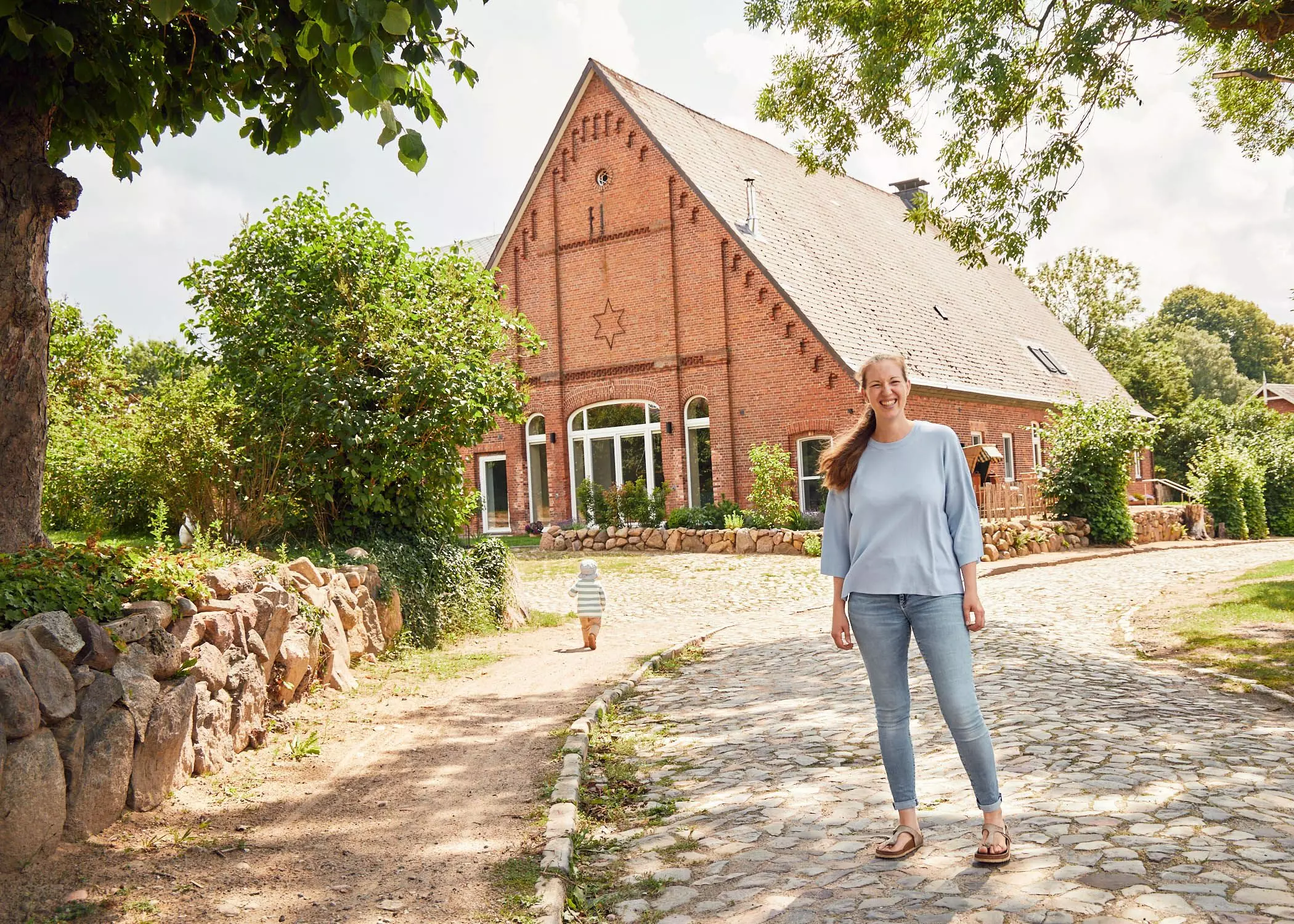 Gesche Marie Drühmel steht vor dem Haus, indem sie mit ihrem Mann, ihren Kindern, ihren Eltern und ihren Großeltern wohnt - femtastics