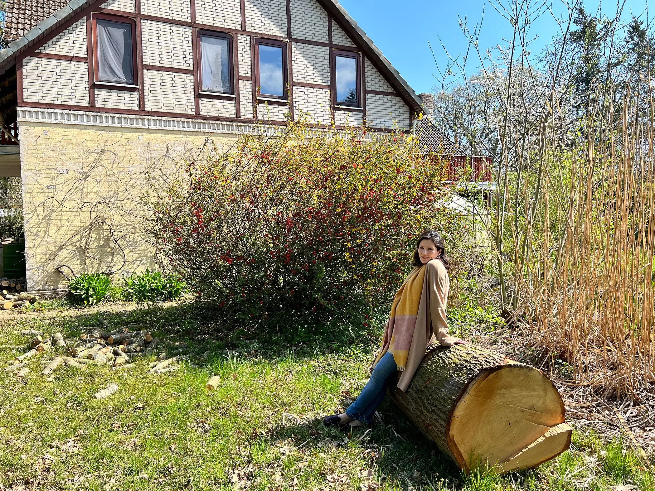Kolumnistin Büsra Qadir sitzt auf einem Eichenstamm in ihrem Garten - femtastics