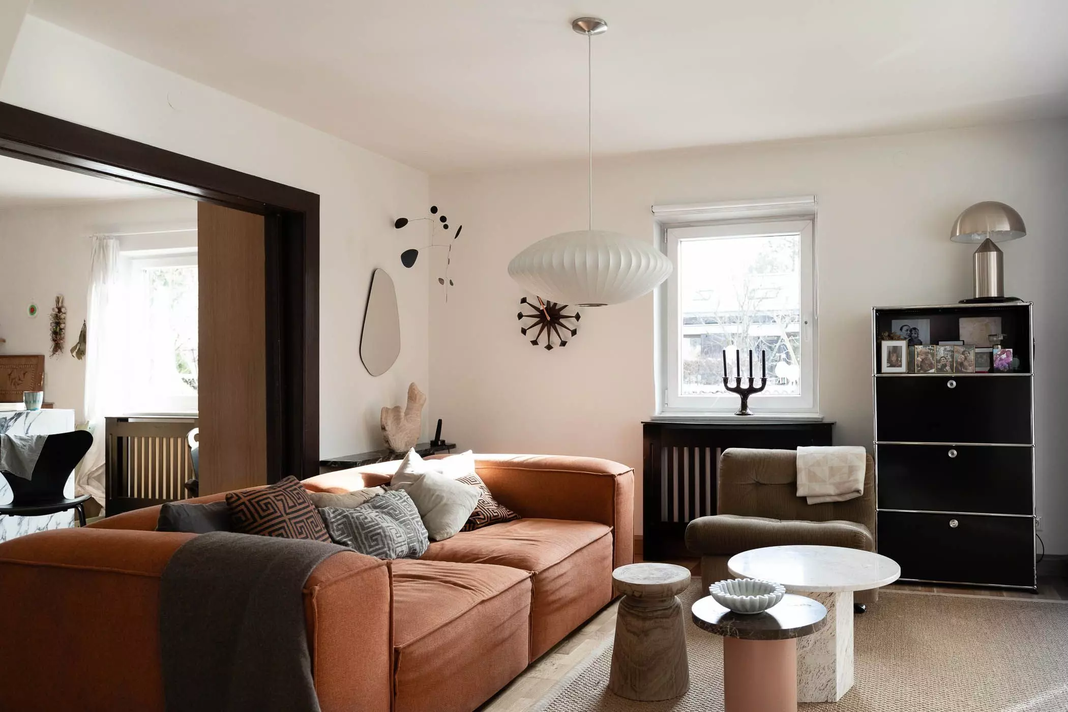 Wohnzimmer mit Sofa, Travertintischen und Wanduhr - femtastics