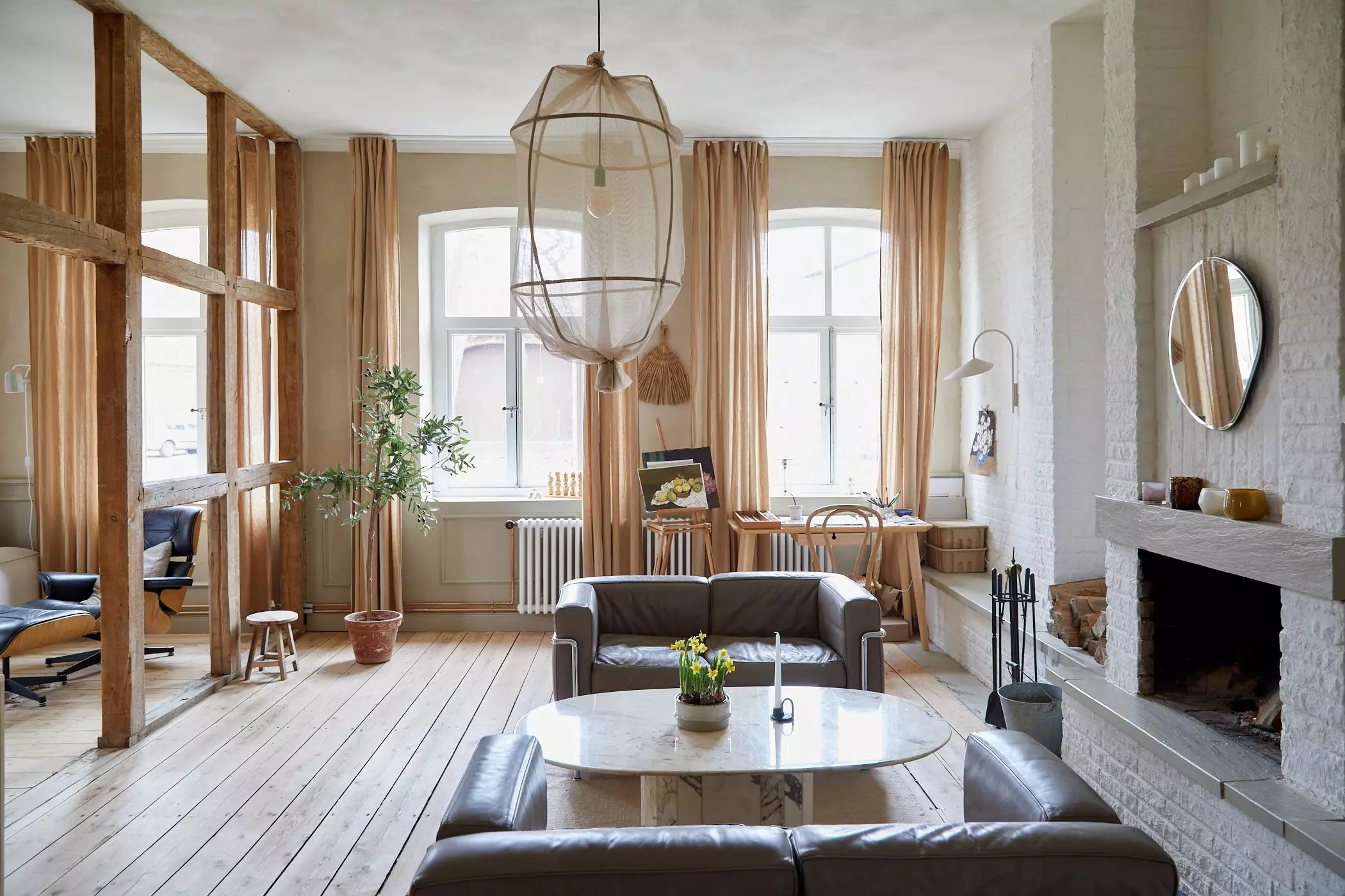 Blick ins offene Wohnzimmer mit Kamin und Holzbalken - femtastics