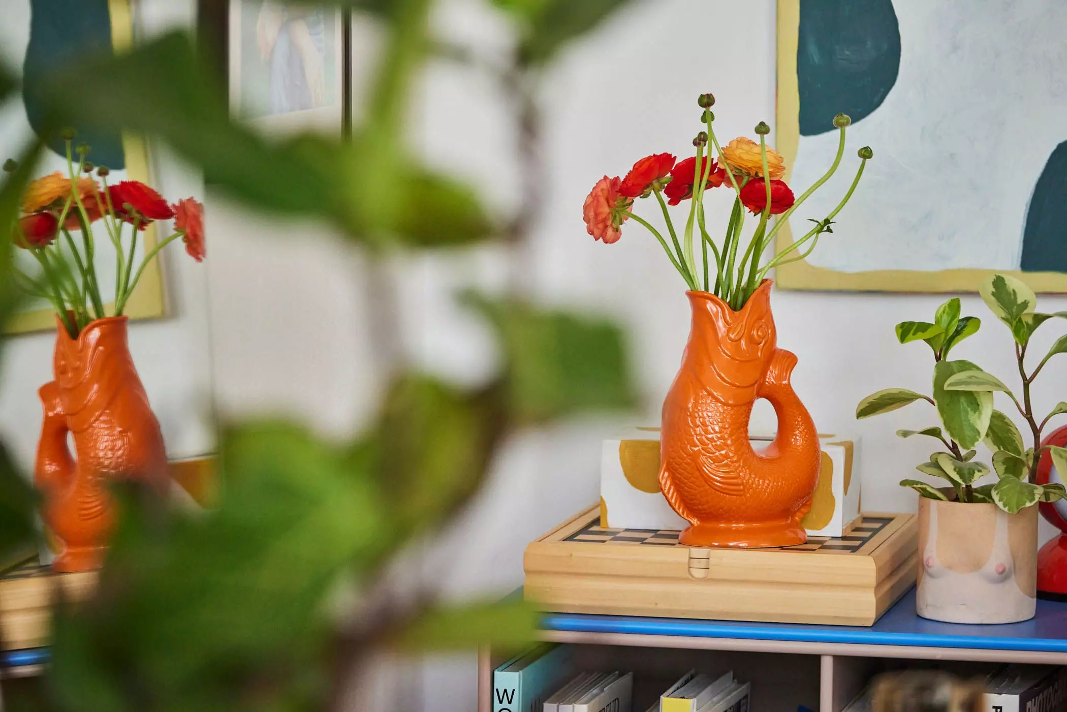 Orangefarbene Fischvase mit Ranunkeln - femtastics