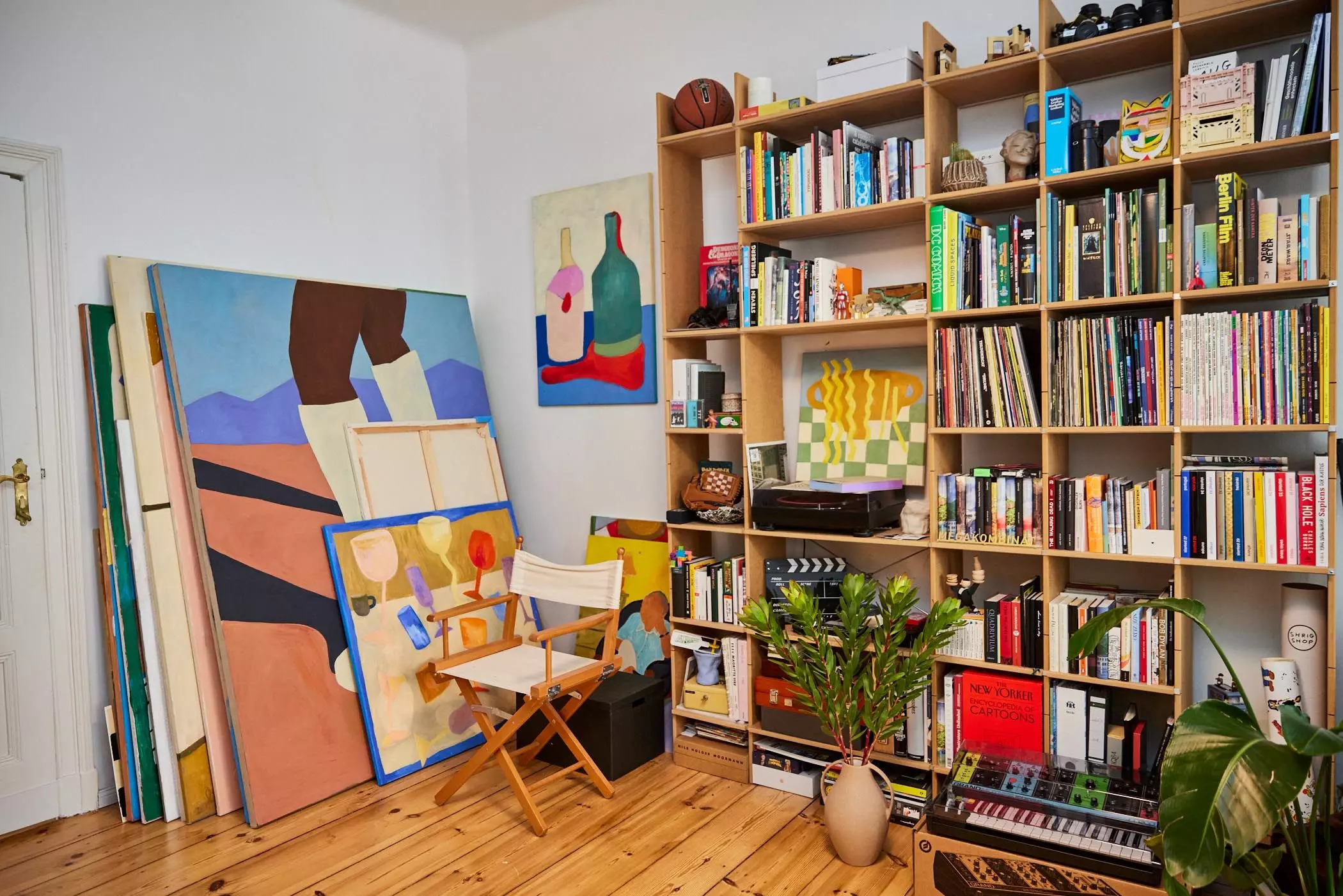 Wohnzimmer mit Gemälden von Fabienne Meyer und großem Regal - femtastics