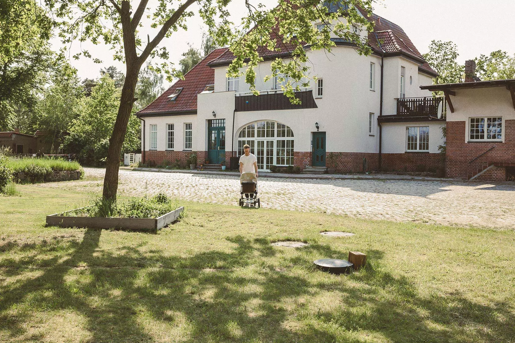 Gero Dusil mit Kinderwagen vor seinem Haus, einem ehemaligen Bahnhof im Havelland - femtastics