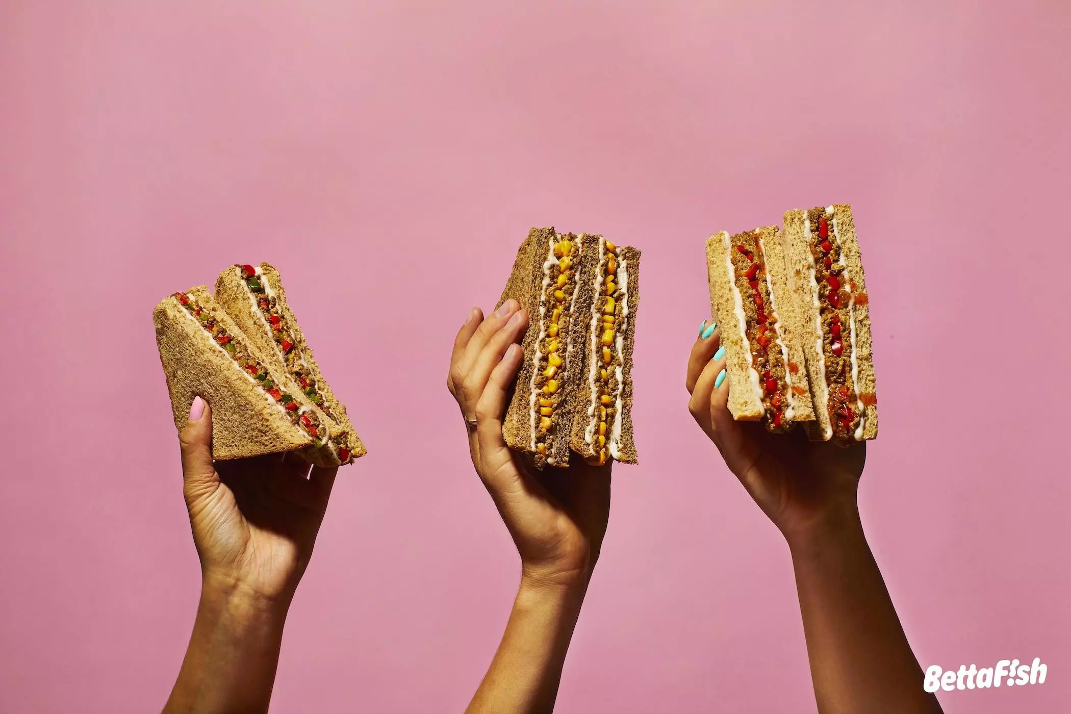 Hände halten die veganen Sandwiches van "Bettafish" - femtastics