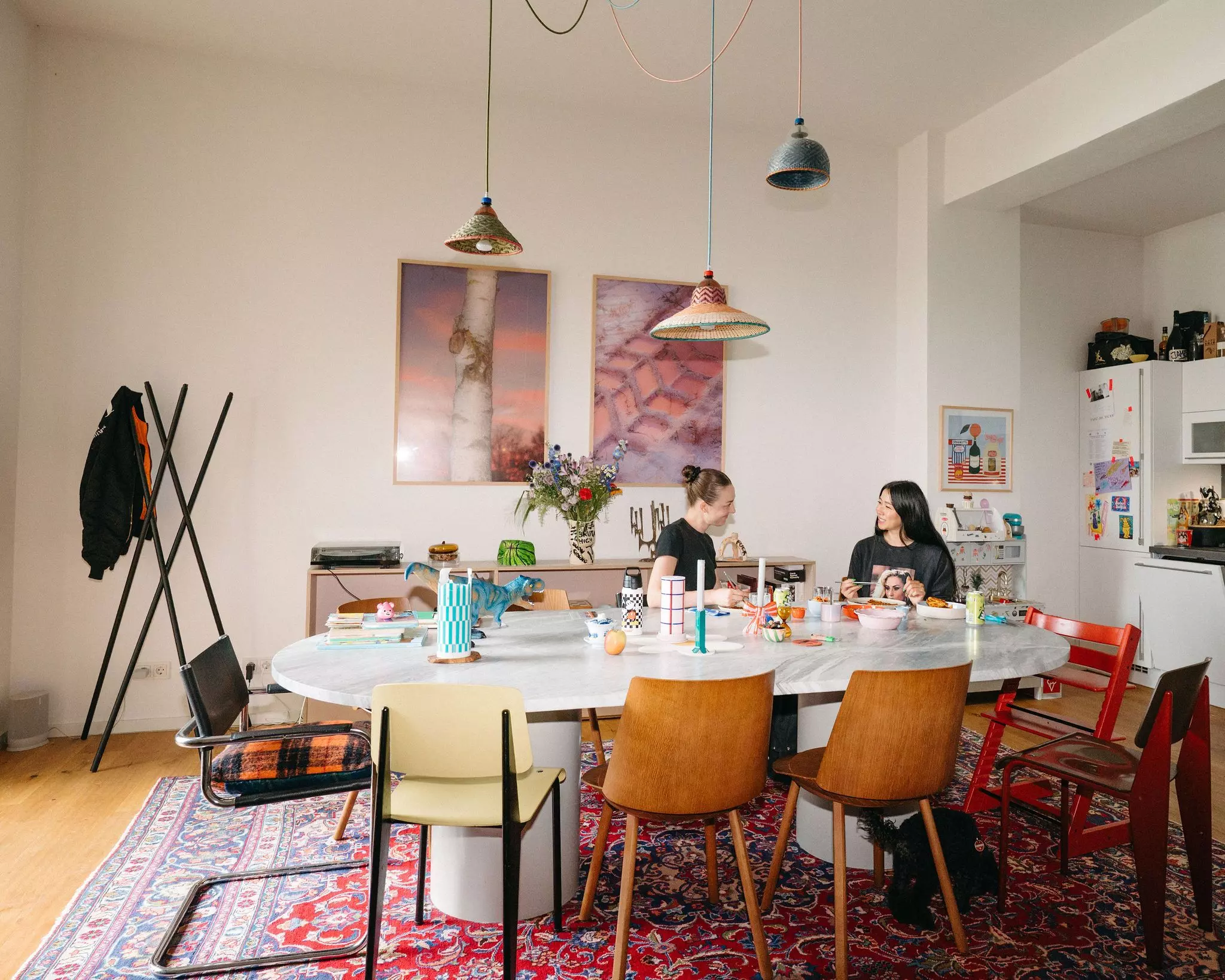 Homestory Ubin Eoh: Die Autorin und ihre Freundin Viola Beuscher sitzen gemeinsam am großen Esstisch in der Wohnküche und essen Kimchipancakes.