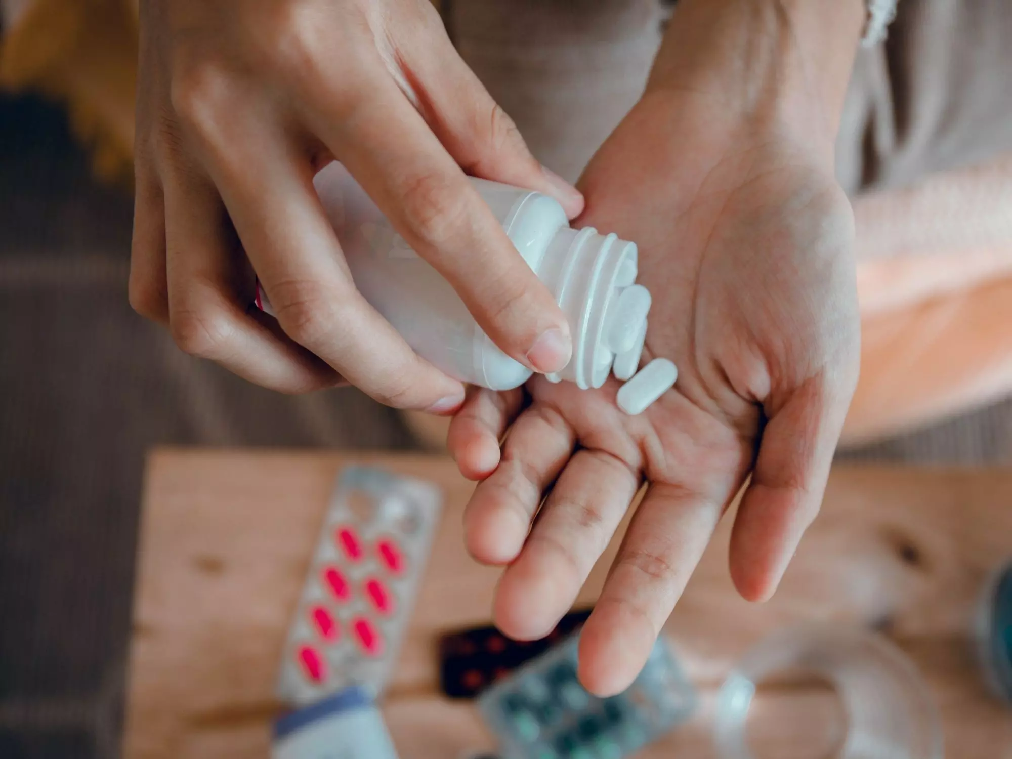 Ein Frau nimmt Tabletten ein – Symbolbild für die Hormonersatztherapie in der Perimenopause.