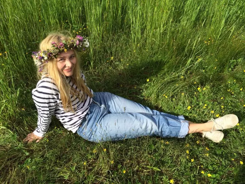 Frau mit Blumenkranz sitzt im Gras | femtastics