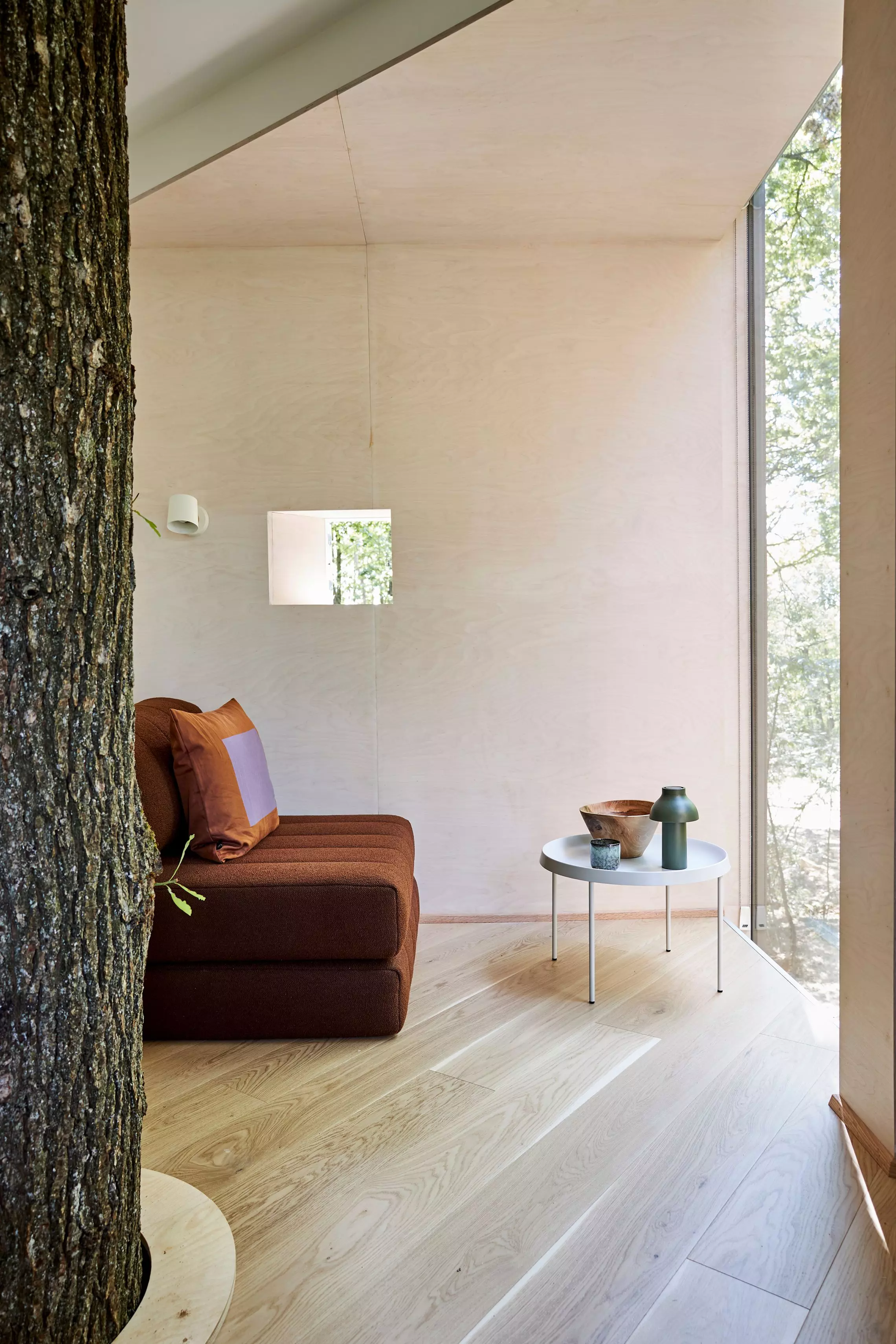 Skandinavisch gestaltetes Interieur mit natuerlichen Materialien in einer Loevtag-Baumhuette.