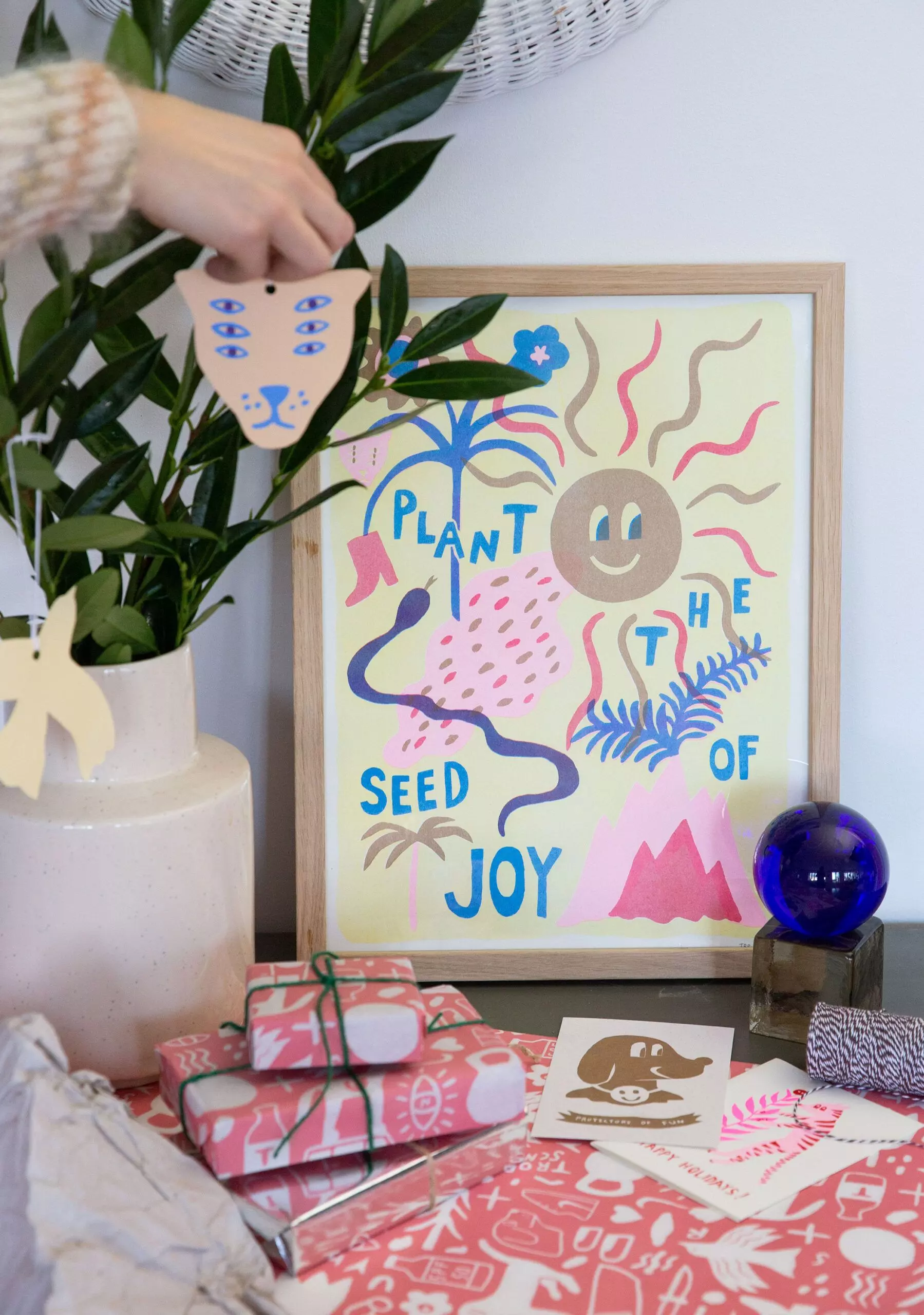 Poster "Plant the Seed of Joy" von "Tropical Scandinavia" und verpackte Geschenke - femtastics