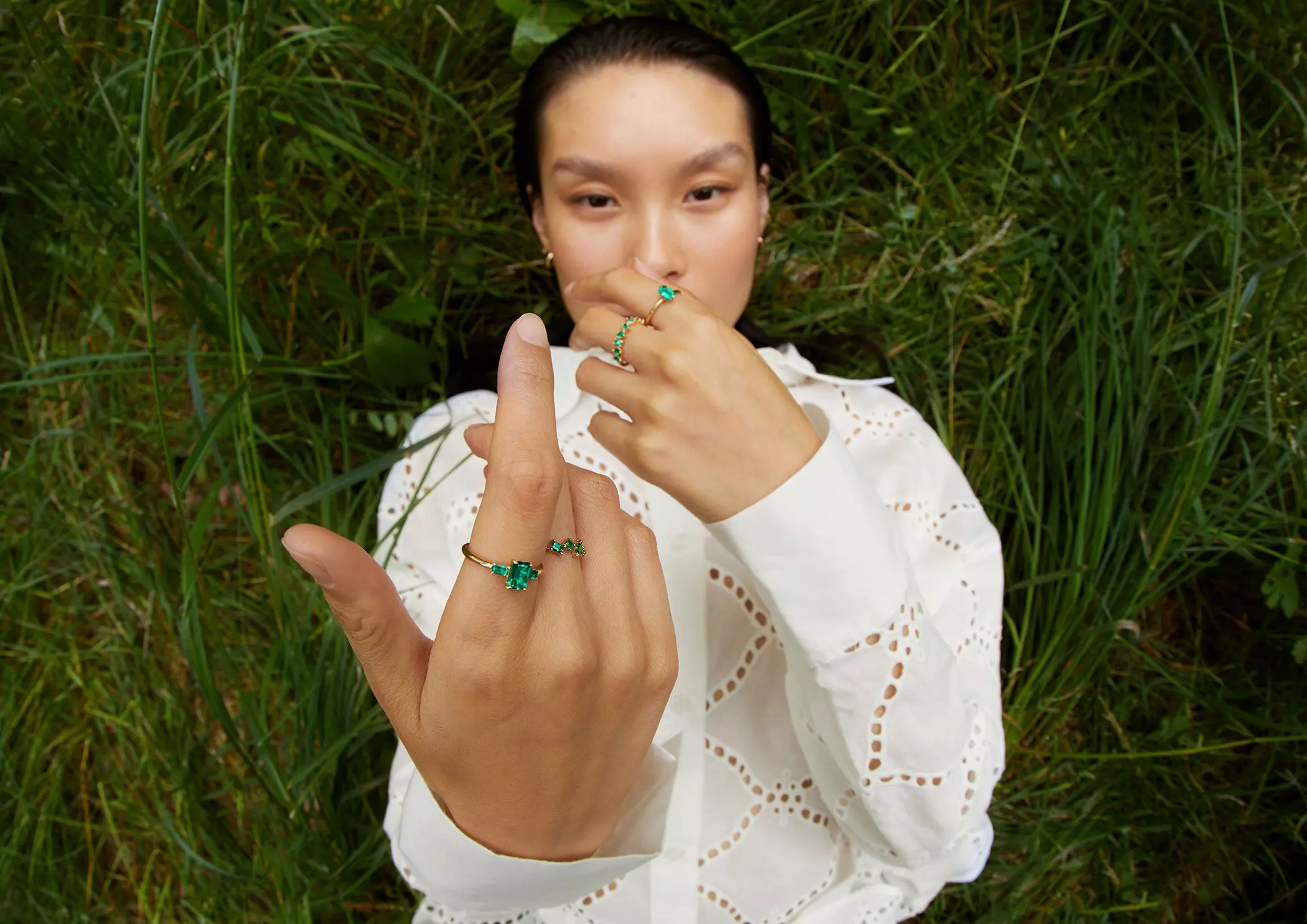 Eine Frau trägt Schmuckringe mit grünen Smaragden – femtastics
