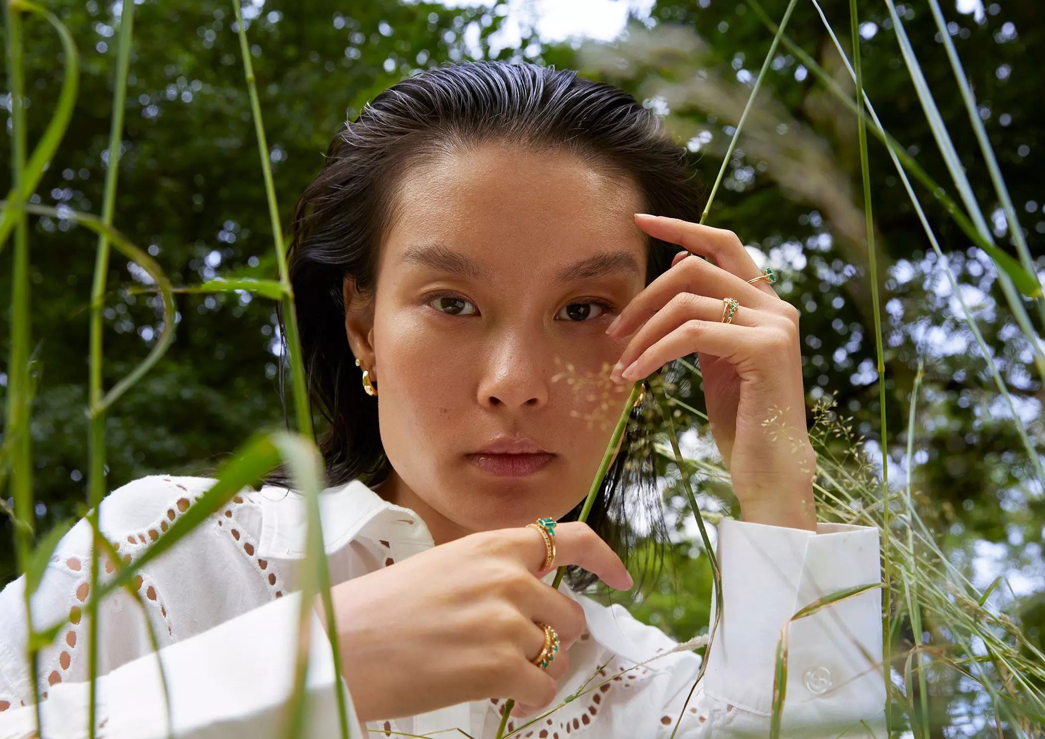 Eine Frau trägt Schmuckringe mit grünen Smaragden – femtastics