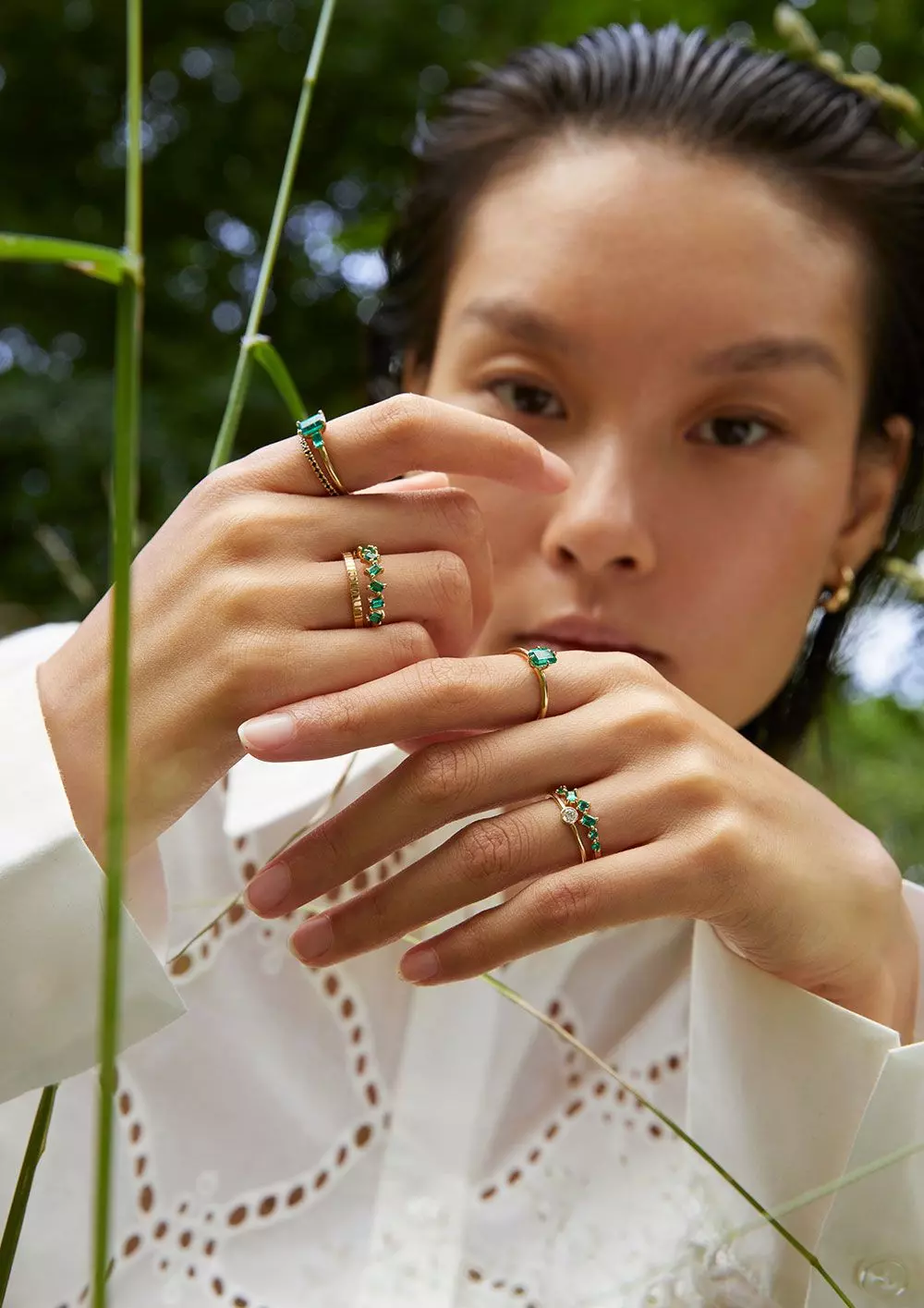 Eine Frau trägt Schmuckringe mit grünen Smaragden – femtastics
