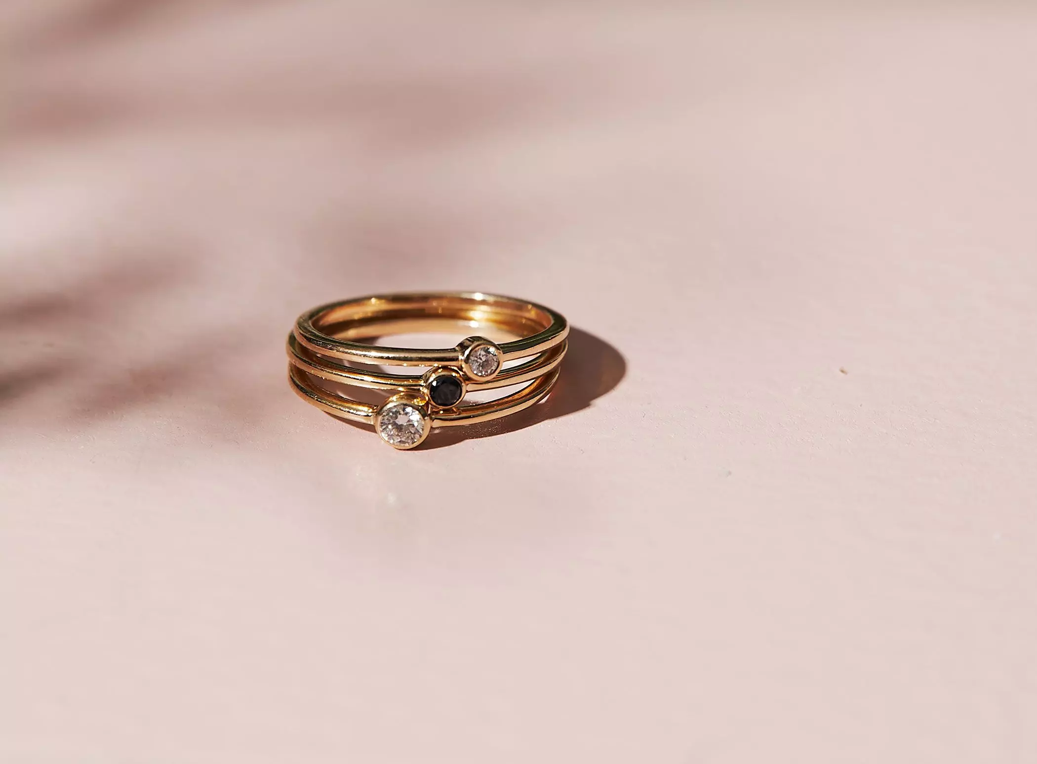 Goldringe mit runden Edelsteinen auf rosa Untergrund – femtastics