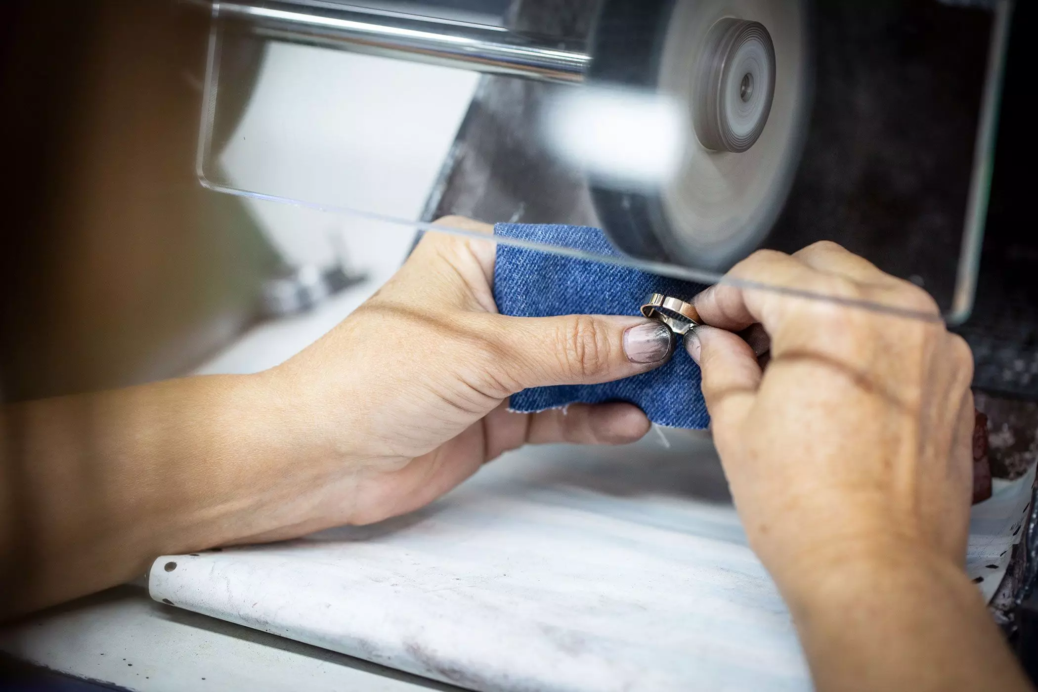 Hände, die an einem Werkzeug an einem Goldring arbeiten – femtastics