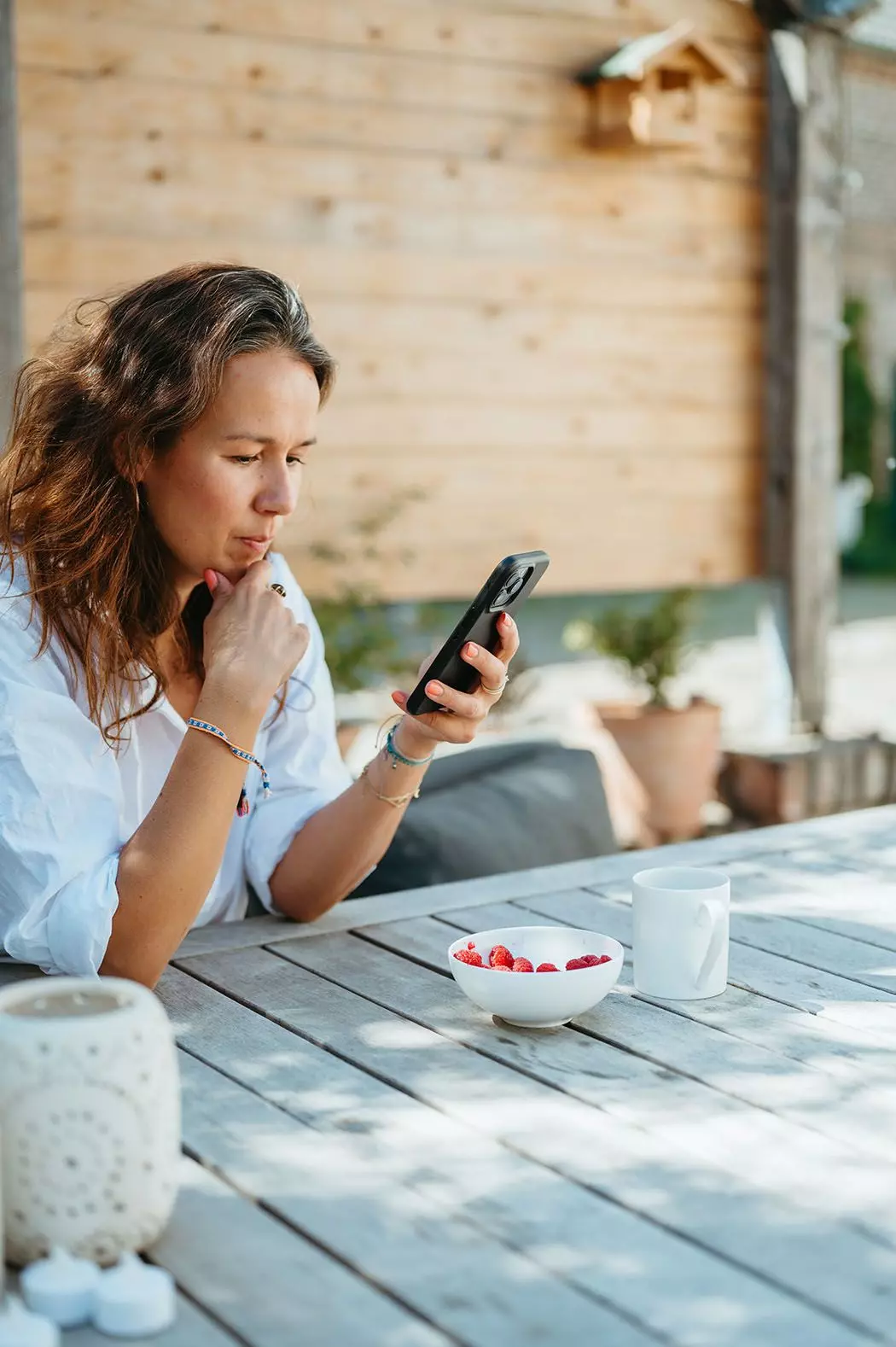 Guya Merkle sieht auf ihrer Terrasse auf ihr Smartphone | femtastics