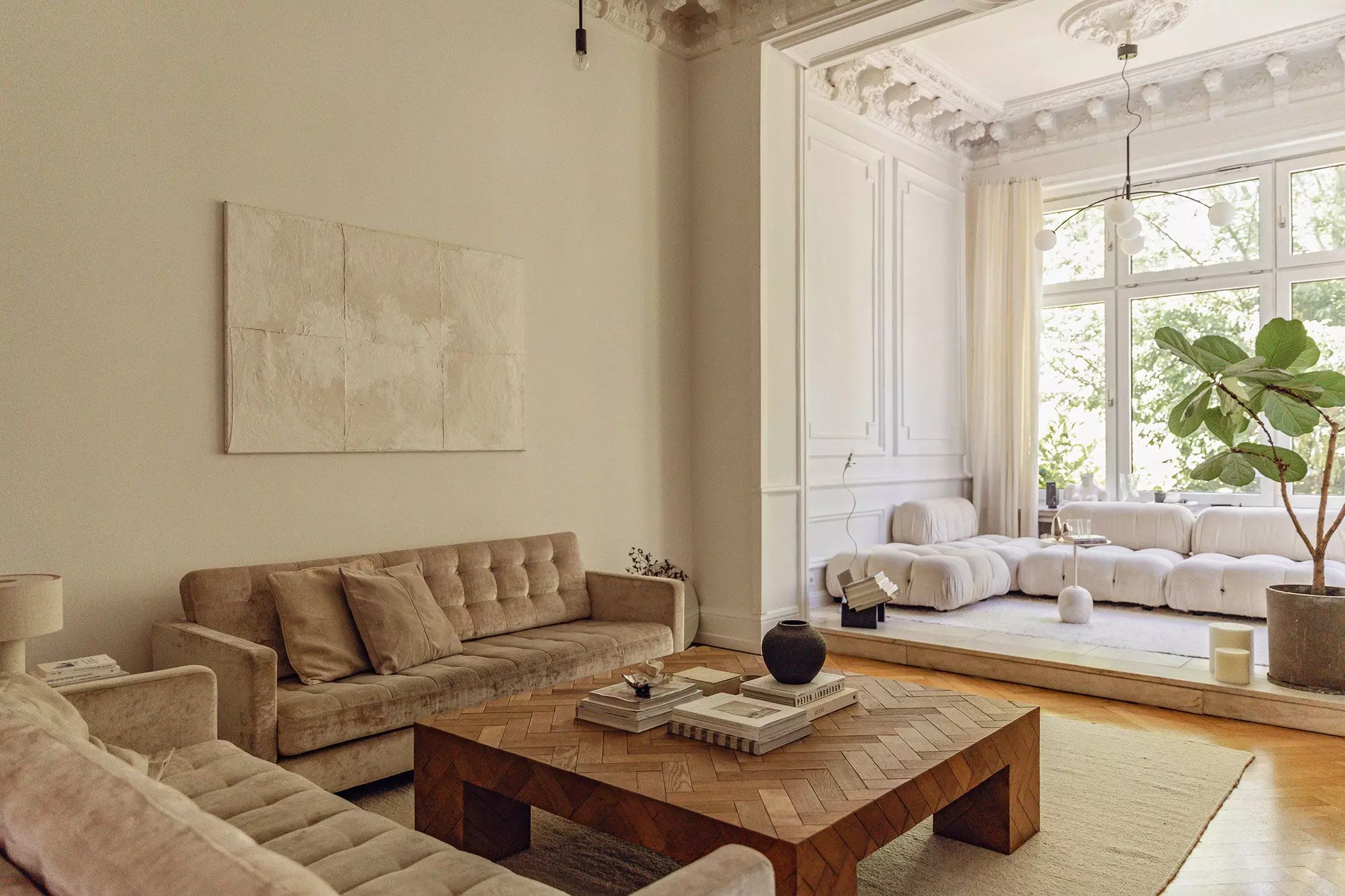 Wohnzimmer in Altbau mit Wintergarten mit Stuck, Sofalandschaft und großem Couchtisch