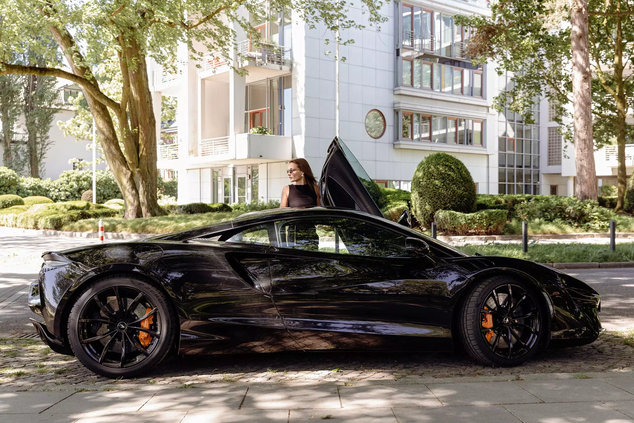 Melina Wendlandt stehend am McLaren Artura mit geöffneter Tür