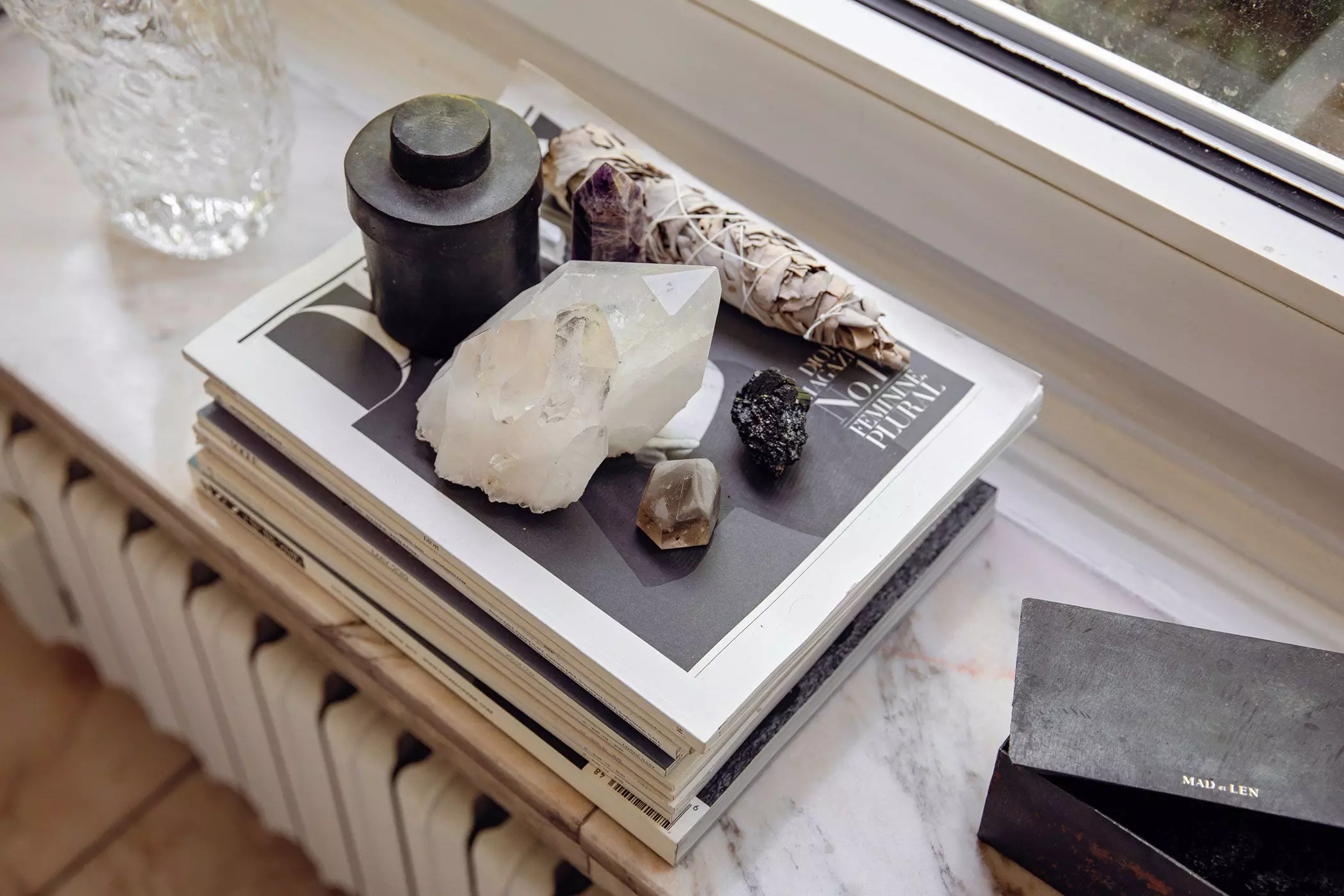 Kristalle und Salbei auf einem Zeitschriftenstapel