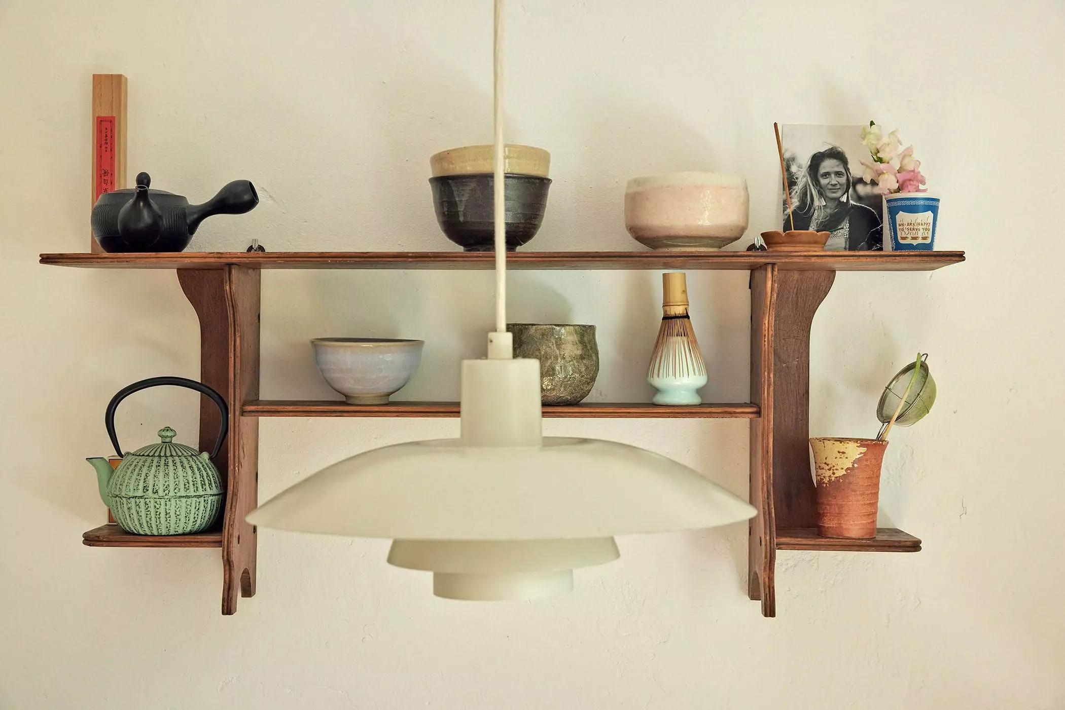 Wandregal mit Matcha-Teebechern, davor eine weiße Deckenlampe - femtastics