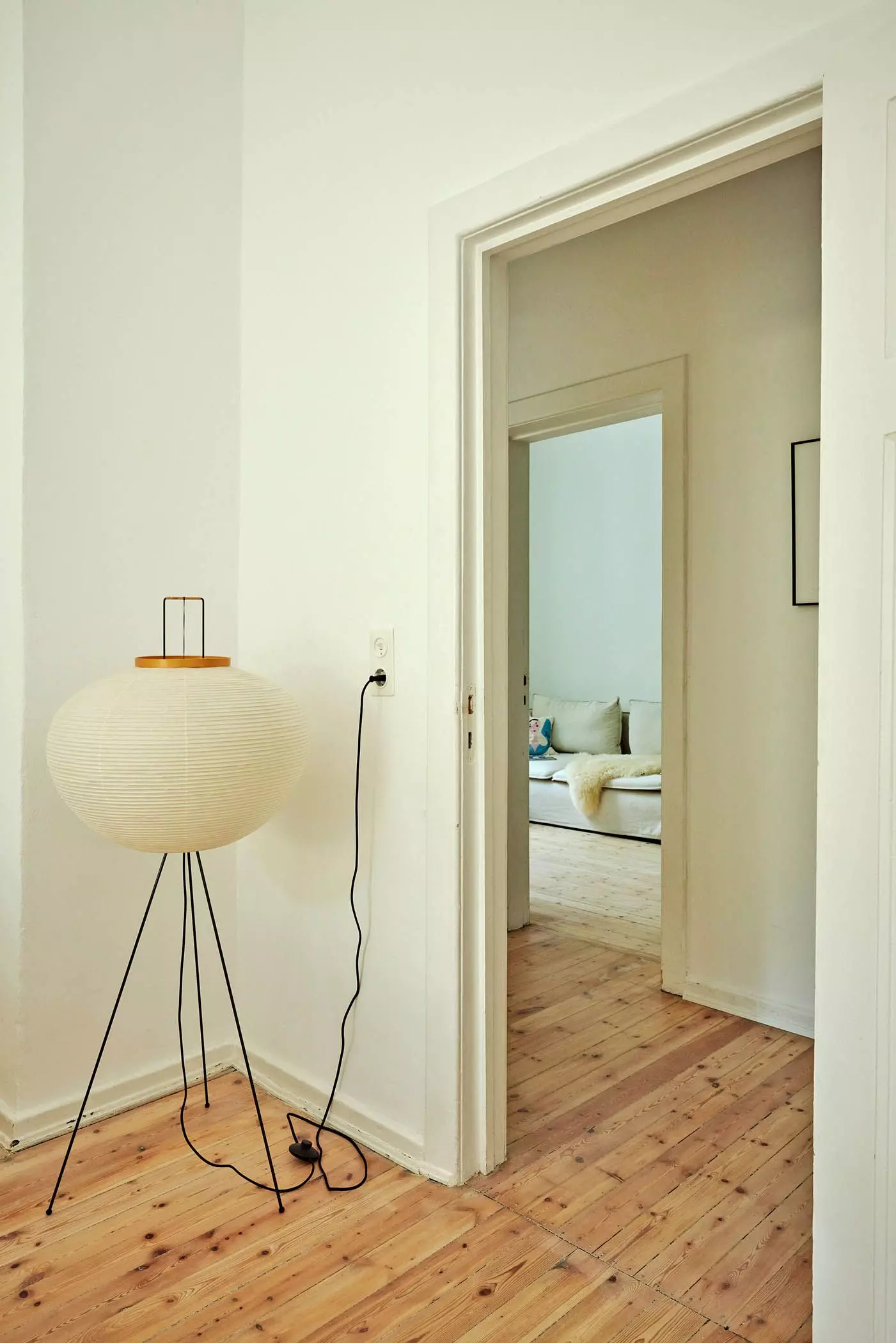 Papierstehlampe neben einer offenen Tür mit Blick in andere Zimmer - femtastics