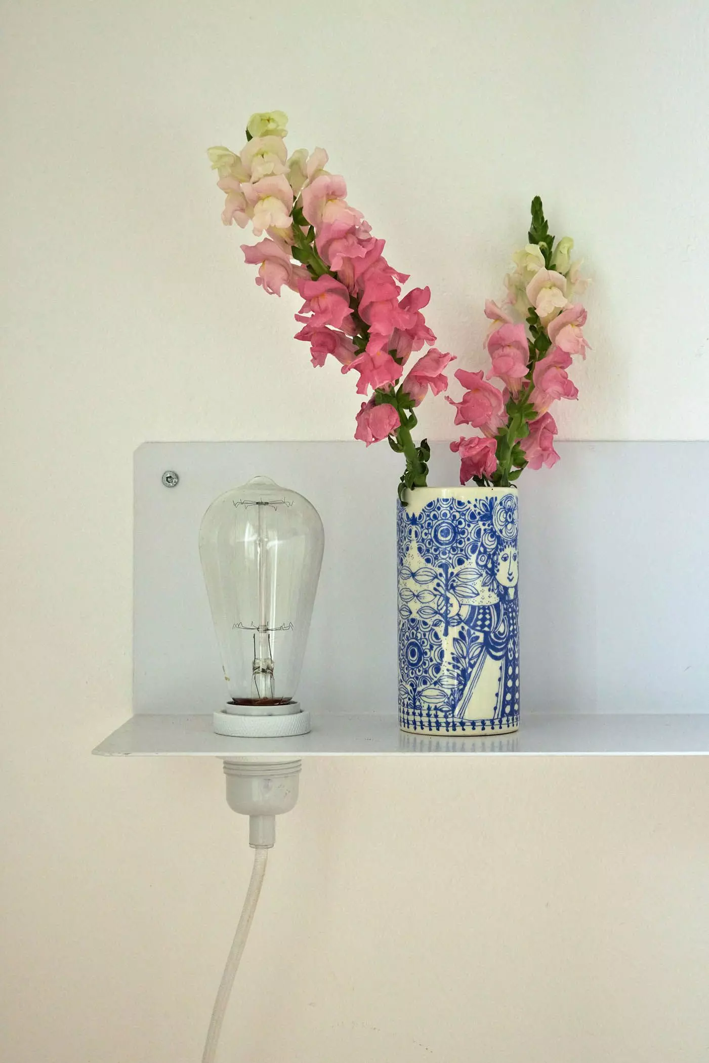 Wandregal mit Glühbirne und rosa Blüten in einer Vase - femtastics