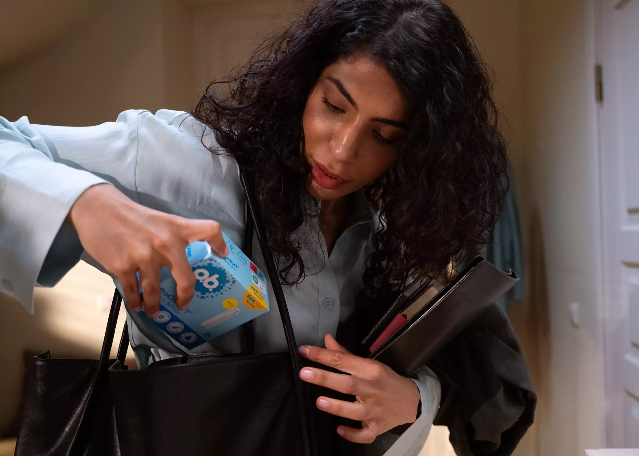 Frau nimmt Tamponpackung aus ihrer Tasche – Symbolbild für Beitrag über Tampon-Mythen
