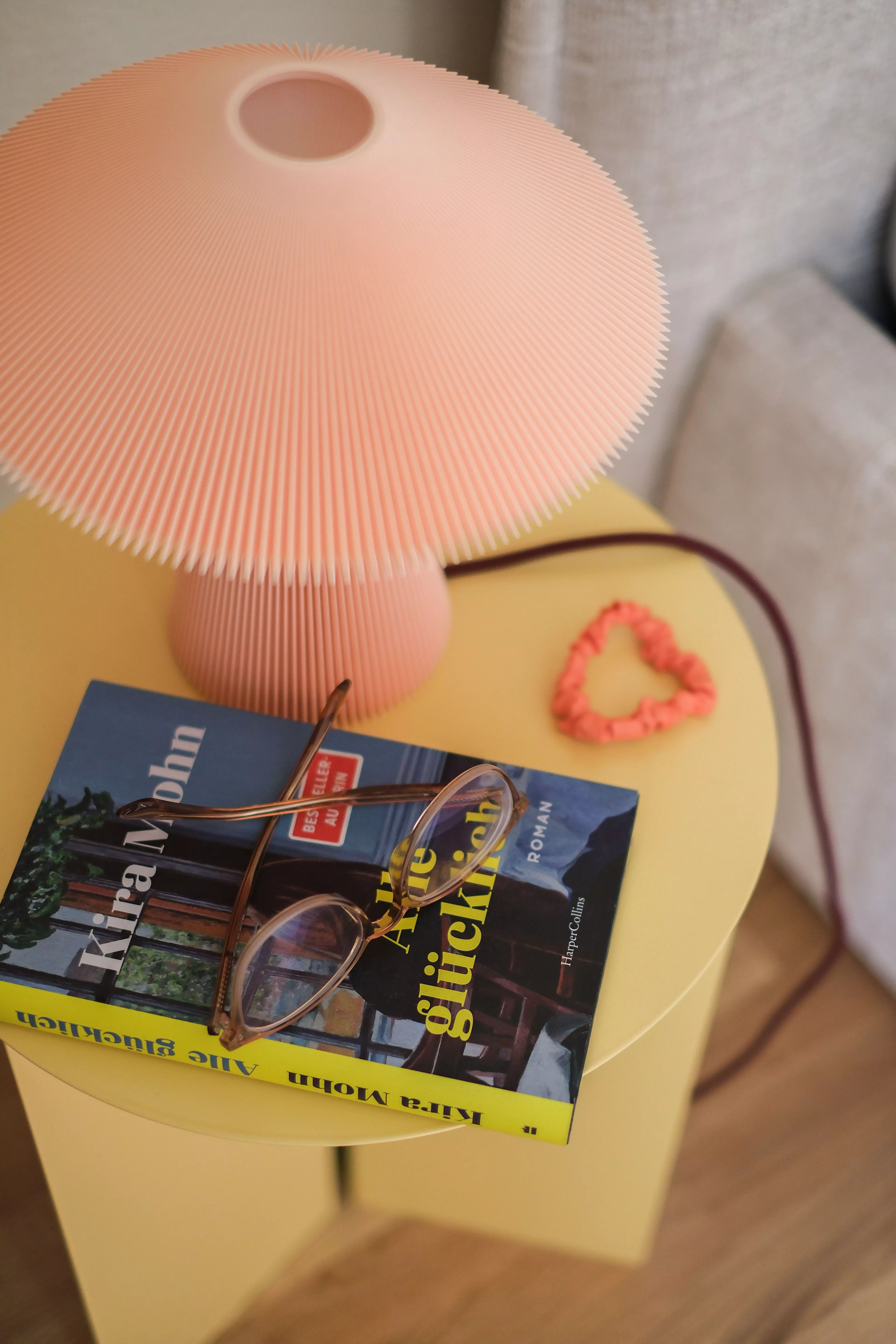 Auf Michaelas Nachttisch liegen ein Buch, eine Brille und ein Haargummi.