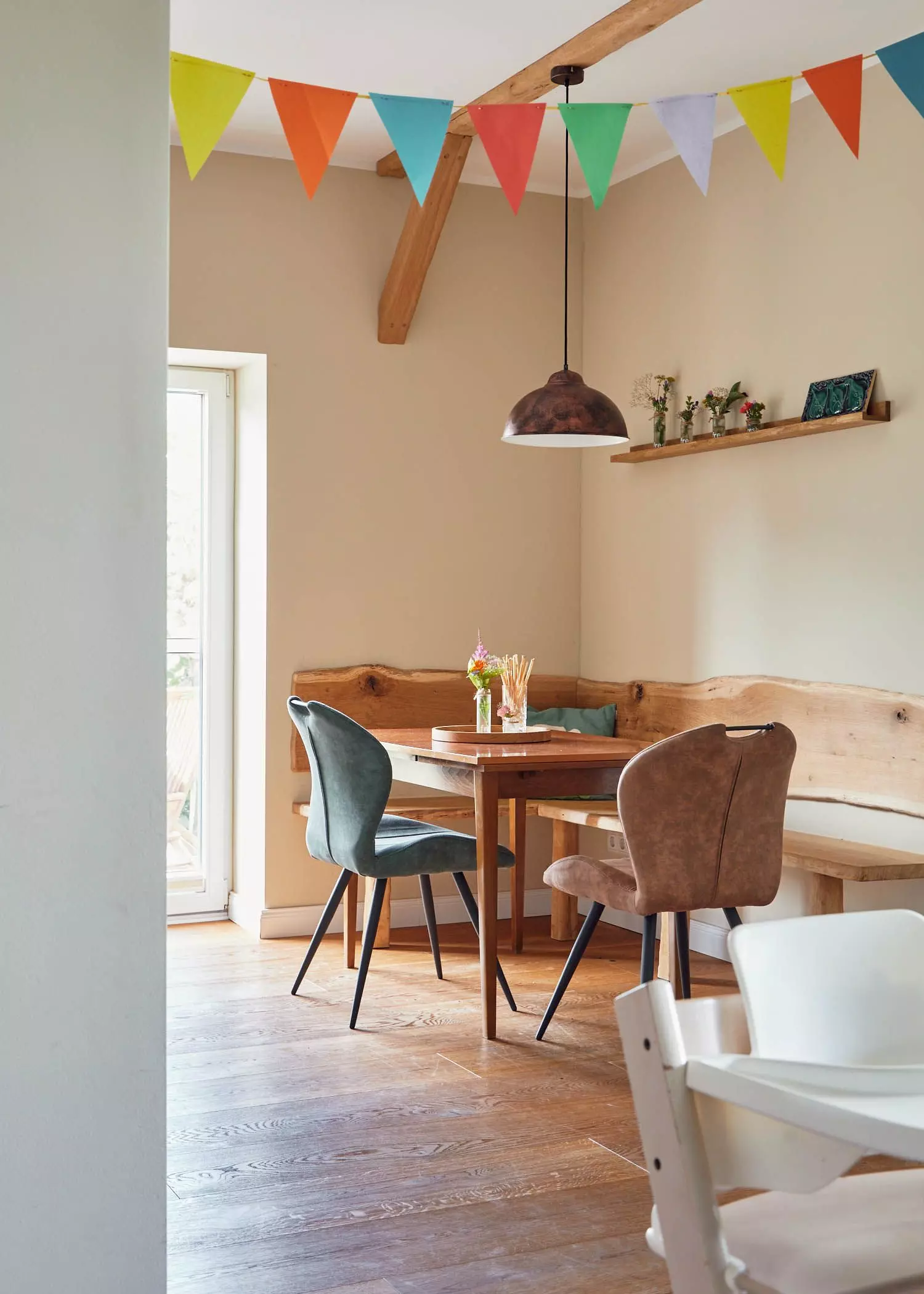 Moderne Sitzecke mit bunter Wimpelkette in ausgebauten Stallungen - femtastics