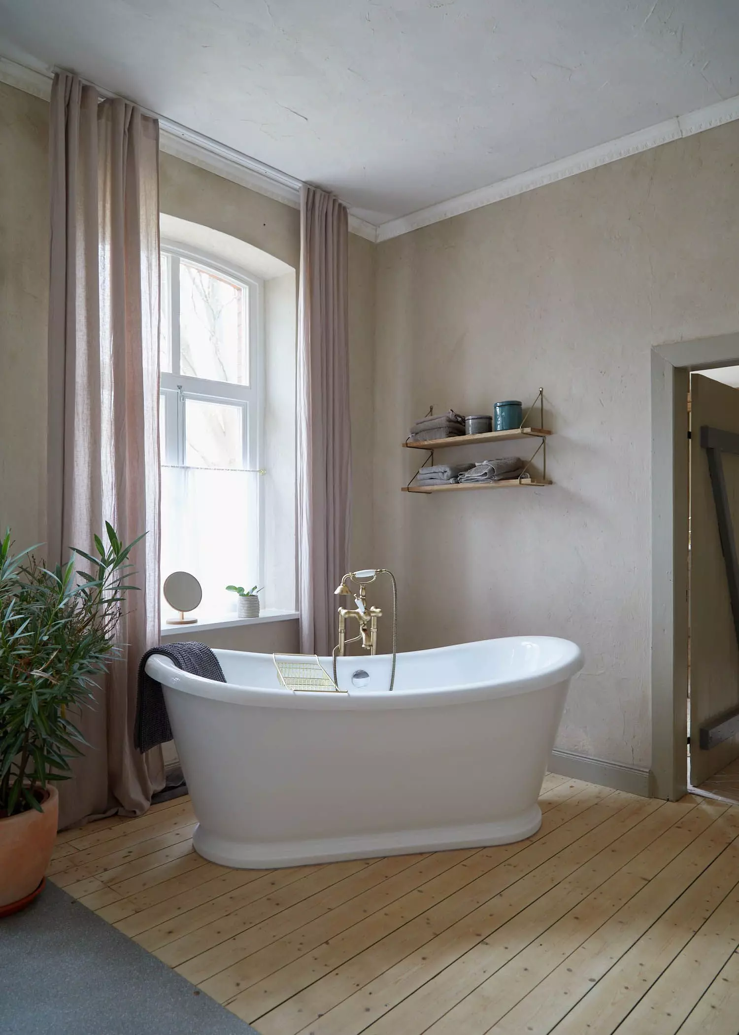 Freistehende Badewanne mit goldenem Wasserhahn und Parkettboden - femtastics