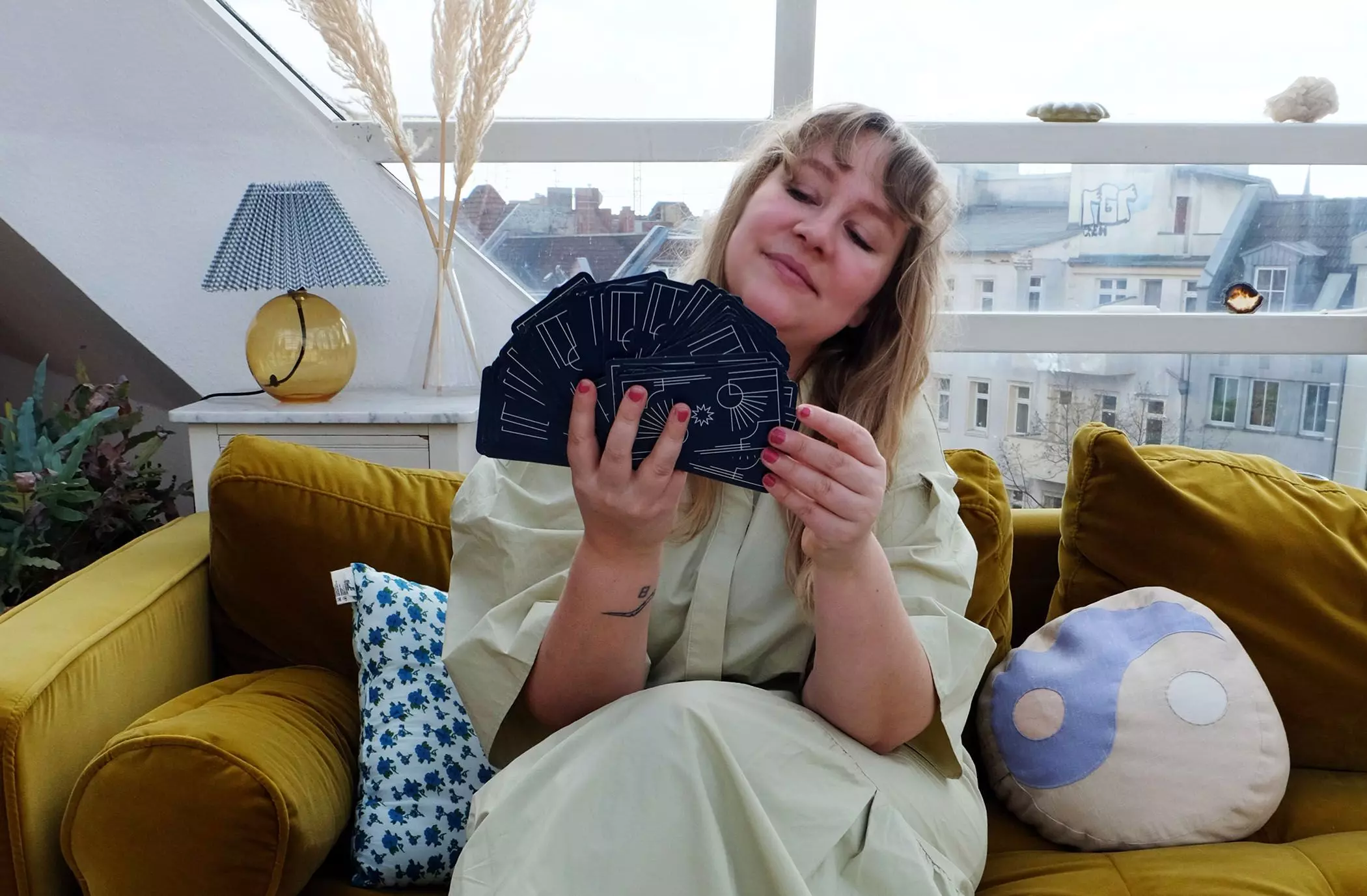 Hannah Krutmann sitzt mit Tarotkarten auf dem Sofa - femtastics