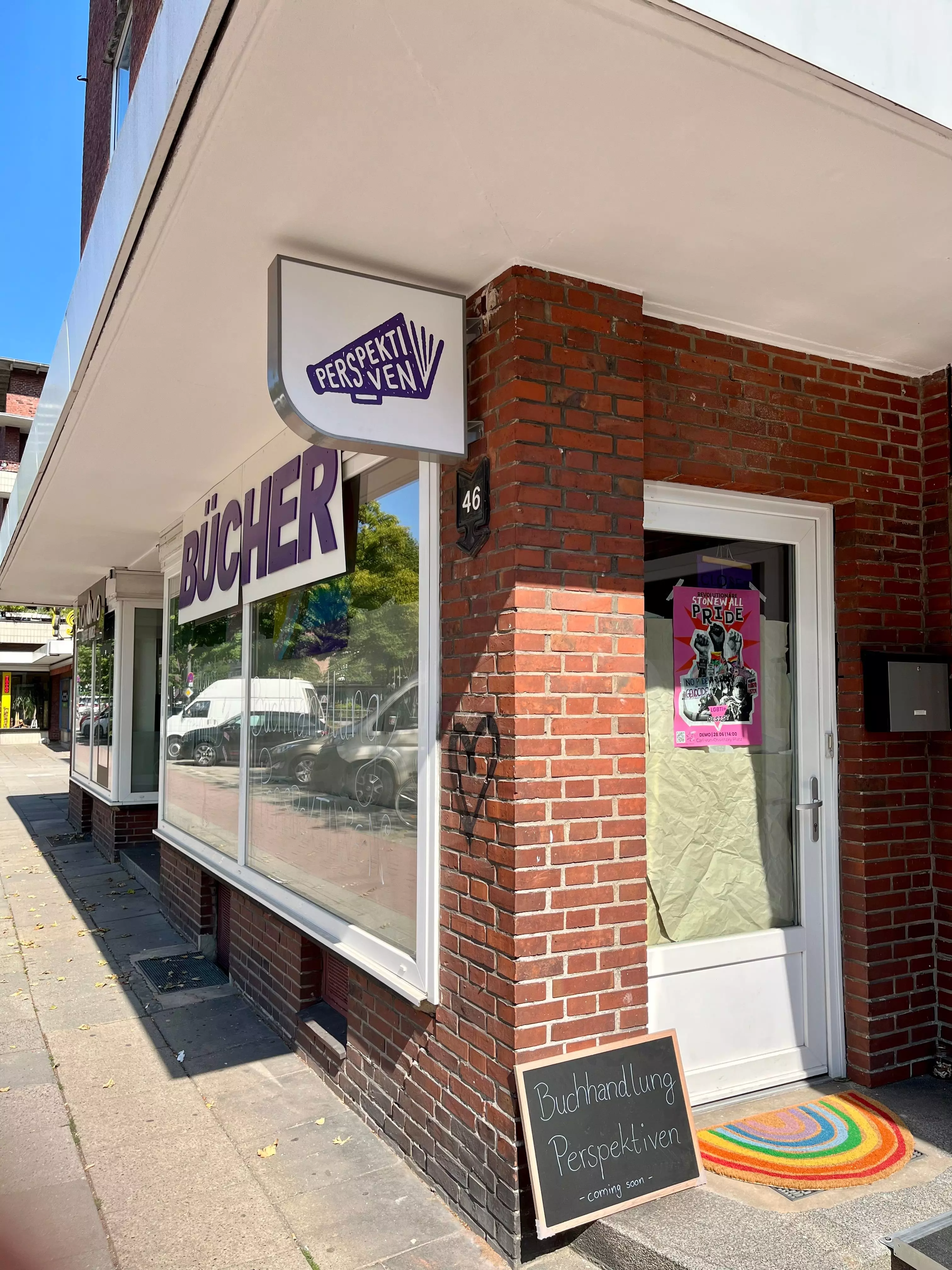 Eingangsbereich des queerfeministischen Buchladens Perspektiven in Hamburg mit Regenbogenfussmatte.