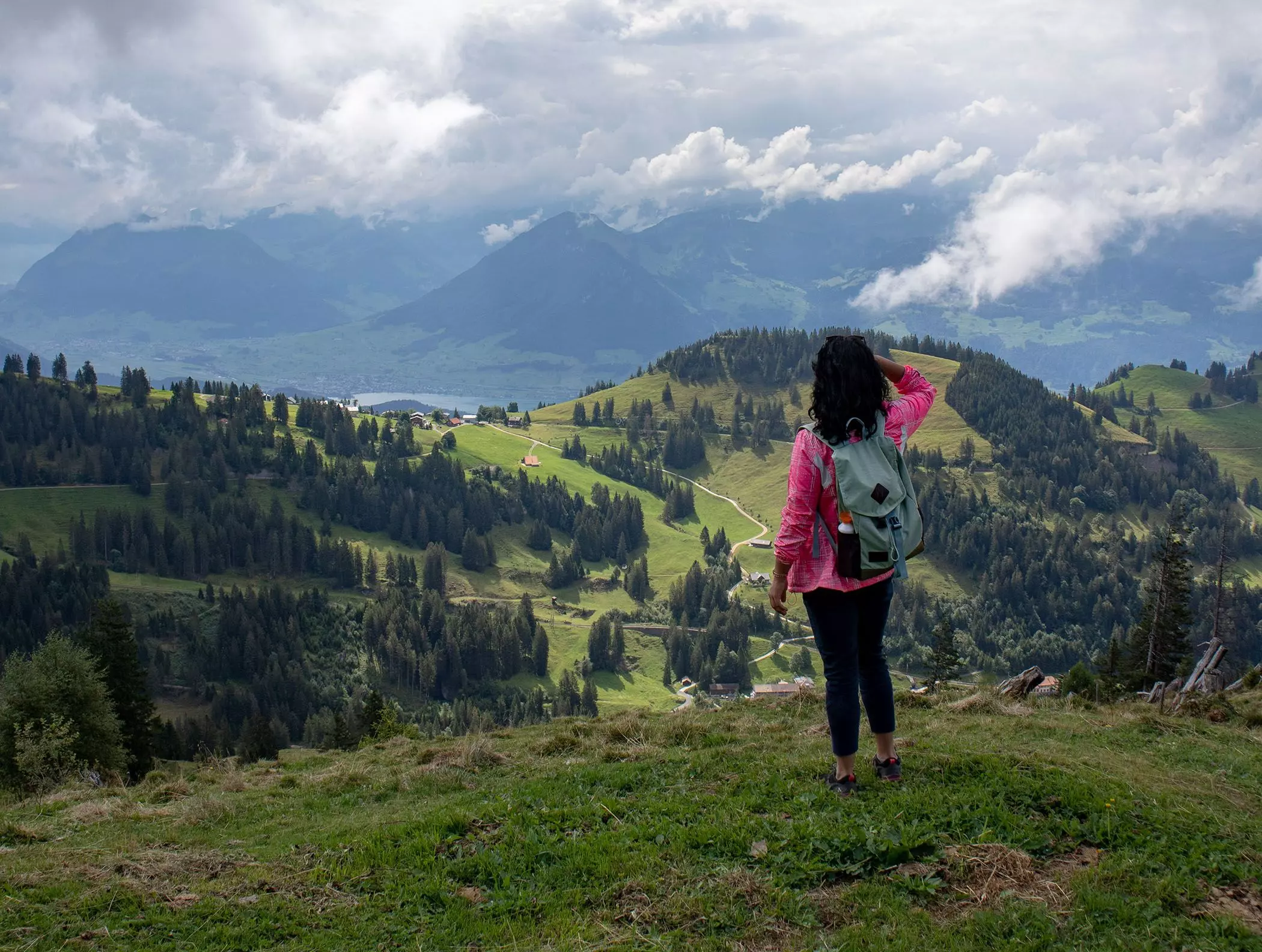 Wanderin steht auf einem Berg und schaut in die Ferne - Solo-Reisen | femtasics