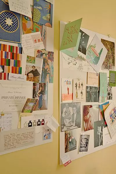 Moodboard mit Zetteln und Postkarten an einer gelben Wand