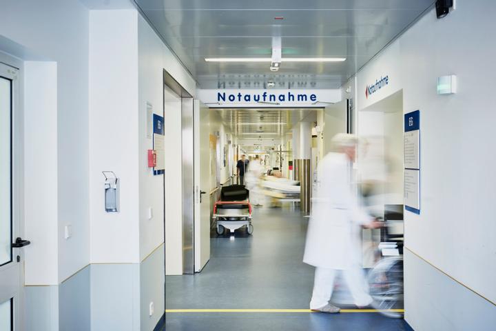 Ein Arzt schiebt einen Patienten durch die Notaufnahme eines Krankenhauses